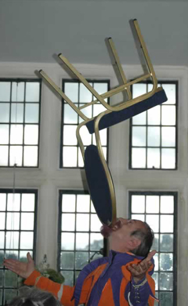 Kris Katchit balances a chair on his chin during a wedding