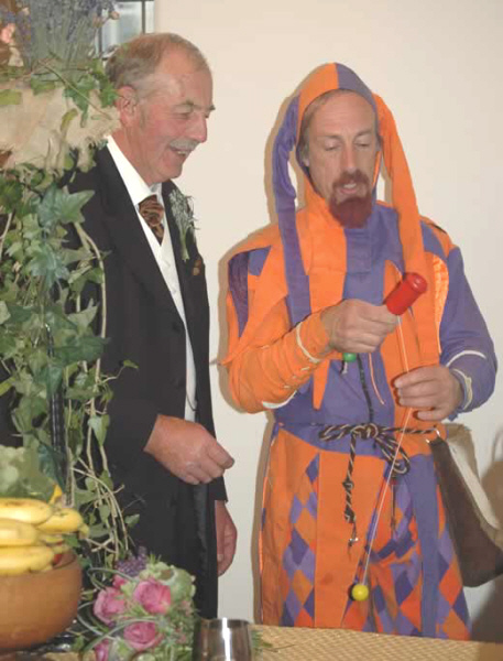 Kris Katchit demonstrates the cup and ball to a gentleman at a wedding.
